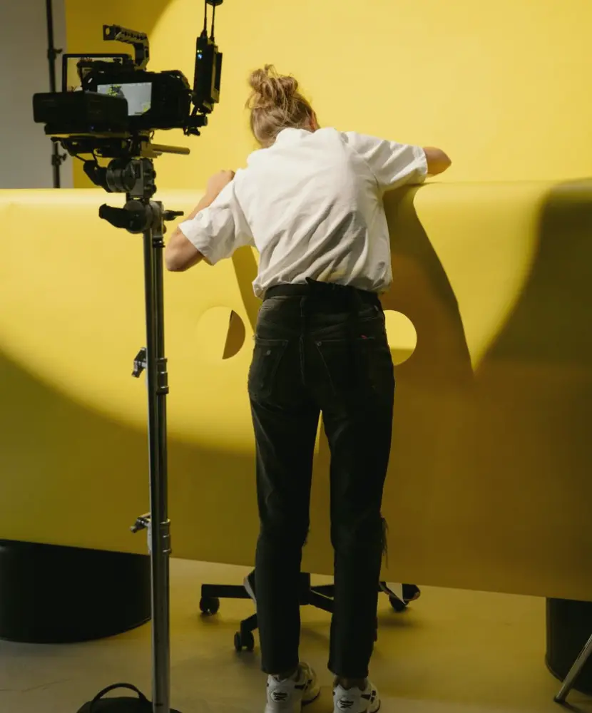 A production crew reviewing a studio floor plan beside a camera and lighting stand